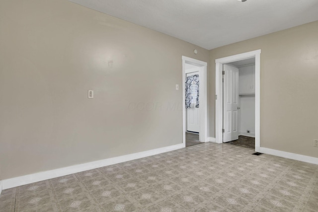 empty room with visible vents, baseboards, and tile patterned floors