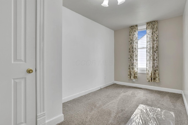 carpeted spare room with baseboards