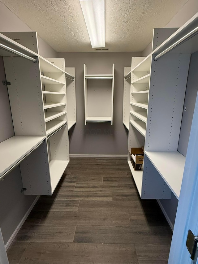 spacious closet featuring dark wood finished floors