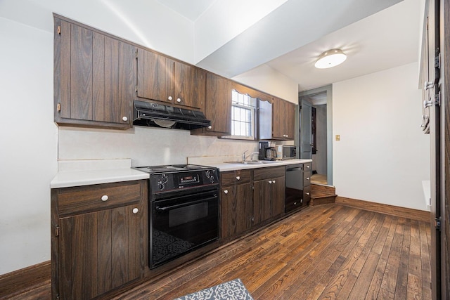 kitchen featuring under cabinet range hood, dark wood-type flooring, baseboards, light countertops, and black appliances