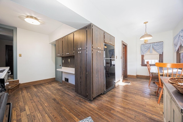 kitchen featuring visible vents, baseboards, dark wood finished floors, and freestanding refrigerator