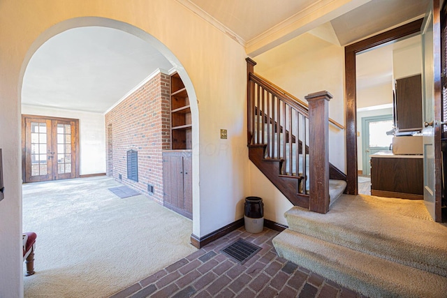 stairs featuring baseboards, ornamental molding, brick floor, french doors, and carpet floors