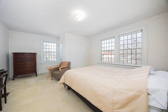 bedroom featuring baseboards and light colored carpet