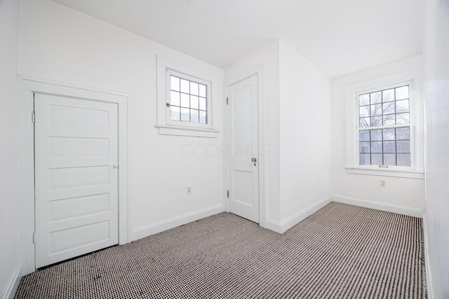 unfurnished room featuring a wealth of natural light and baseboards