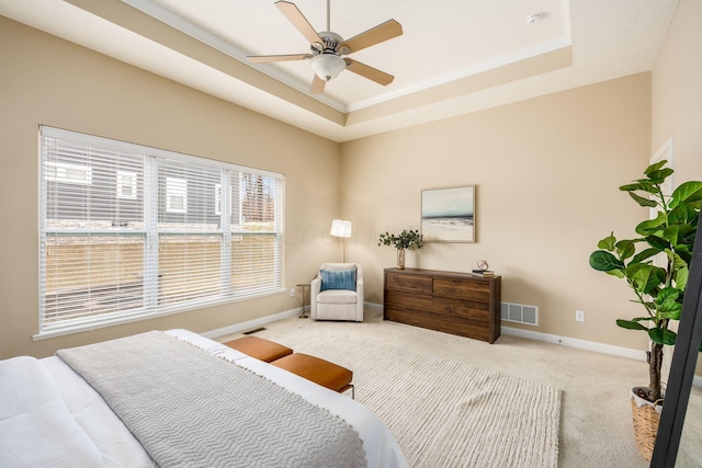 carpeted bedroom with baseboards, visible vents, and a raised ceiling