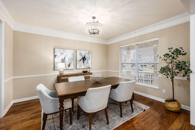 dining room with baseboards, dark wood-type flooring, ornamental molding, and a notable chandelier