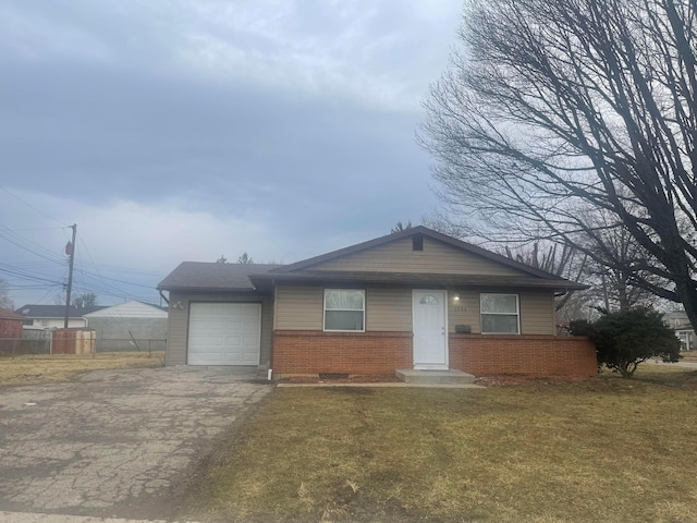 view of front of property with aphalt driveway, a garage, brick siding, fence, and a front lawn