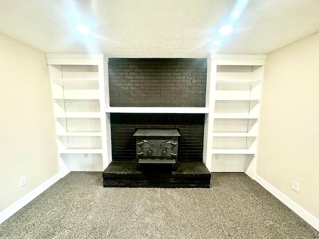 unfurnished living room with carpet, baseboards, and a textured ceiling