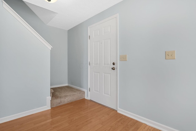 foyer featuring baseboards and light wood finished floors