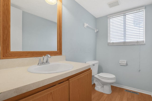 bathroom with visible vents, vanity, toilet, and wood finished floors