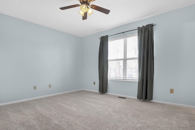 unfurnished room with light carpet, baseboards, visible vents, and a ceiling fan