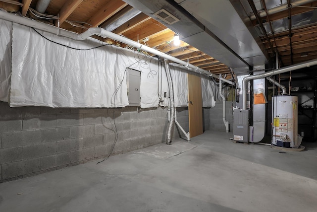 unfinished basement with gas water heater, electric panel, and heating unit