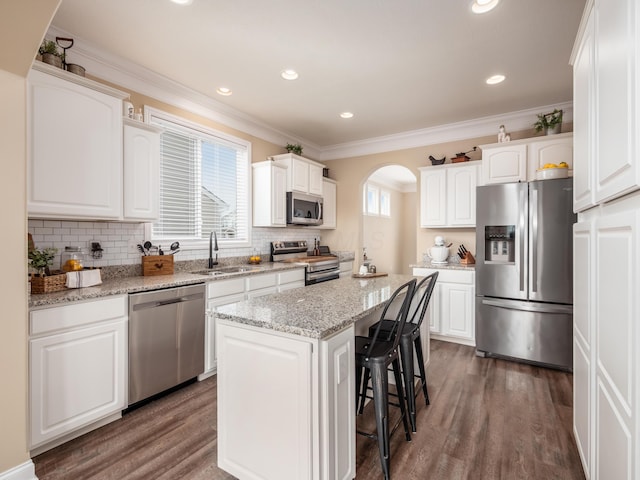 kitchen featuring stainless steel appliances, a kitchen island, and white cabinetry