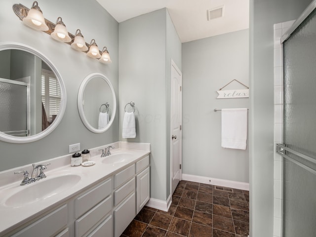 bathroom with an enclosed shower, a sink, visible vents, and baseboards