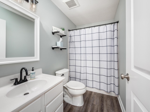 bathroom featuring visible vents, toilet, wood finished floors, curtained shower, and vanity