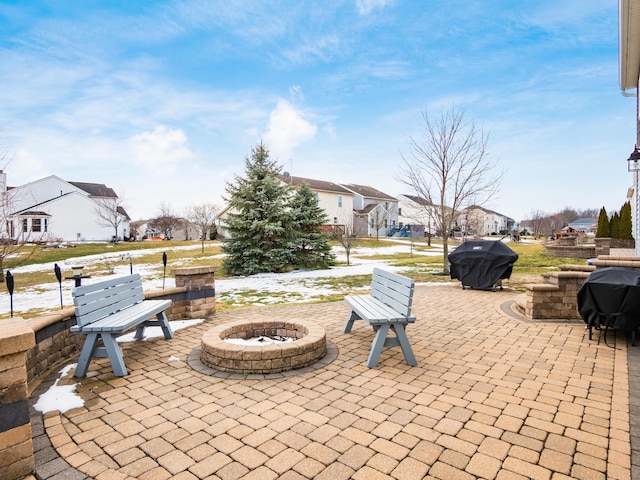 view of patio / terrace with an outdoor fire pit, a residential view, and a grill