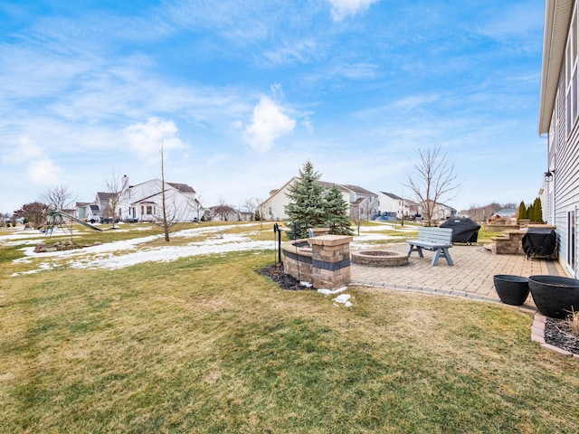 view of yard with an outdoor fire pit, a residential view, and a patio