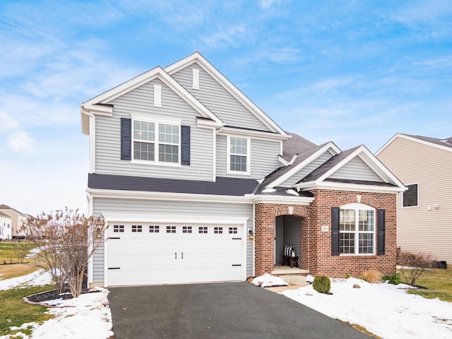 traditional home with aphalt driveway, brick siding, and a garage