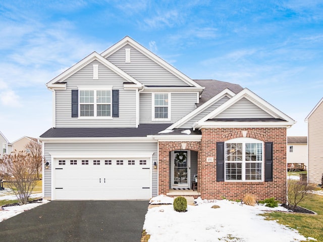 traditional-style house with driveway, a garage, and brick siding