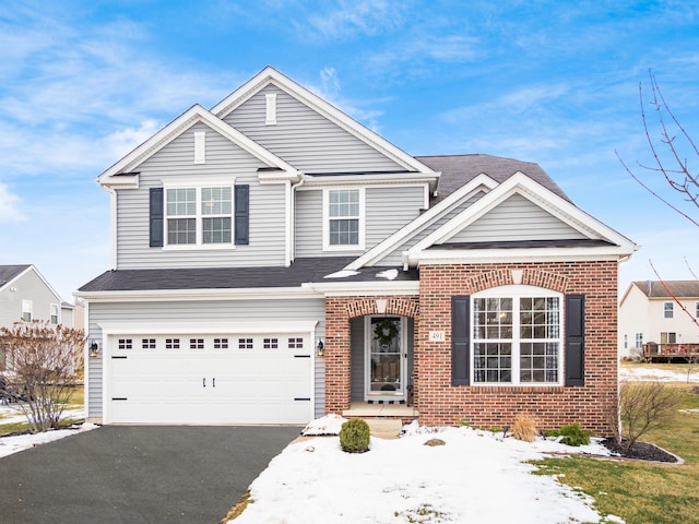 traditional home with a garage, aphalt driveway, and brick siding