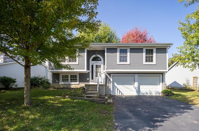 raised ranch featuring driveway, an attached garage, and a front lawn