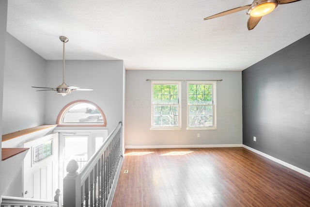 interior space featuring a textured ceiling, baseboards, and wood finished floors