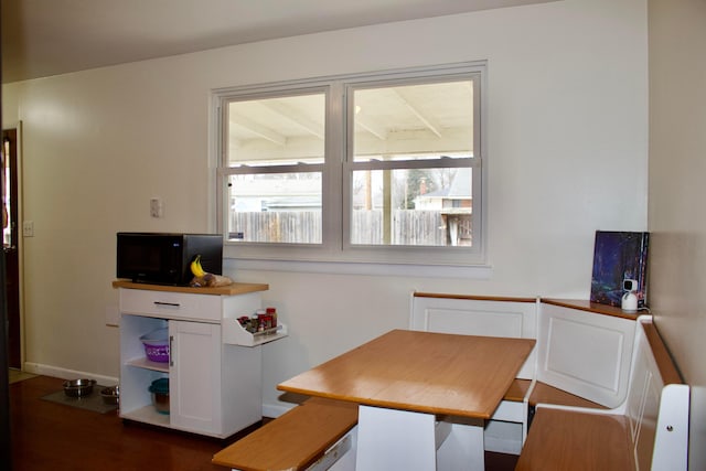 dining space with dark wood-style flooring and baseboards