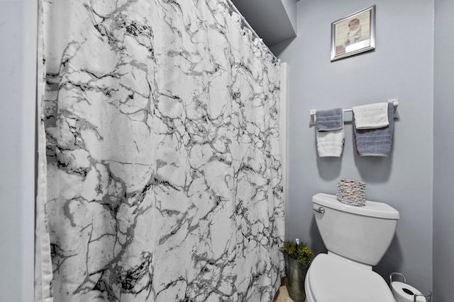 bathroom featuring toilet and a shower with curtain