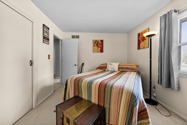 bedroom with light carpet, visible vents, and baseboards