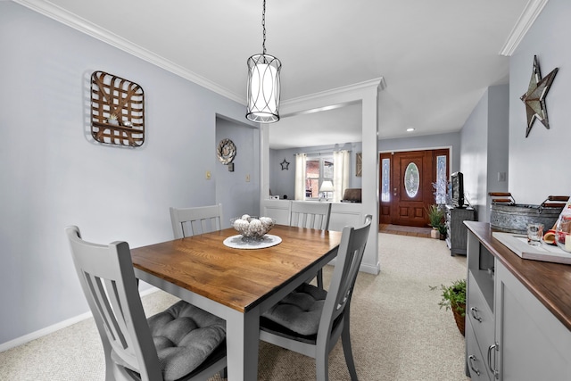 dining room with light carpet, crown molding, and baseboards