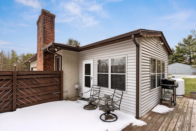 exterior space featuring a chimney, fence, and a wooden deck