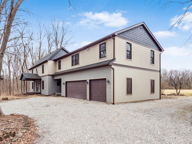 view of side of property featuring driveway and an attached garage