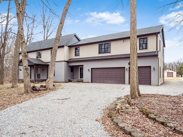 view of front facade featuring a garage, roof with shingles, and gravel driveway