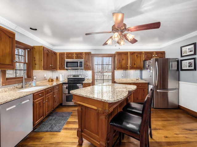 767 London Groveport Rd, Lockbourne, OH 43137 - kitchen featuring stainless steel appliances, wood finished floors, a kitchen island, a sink, and crown molding