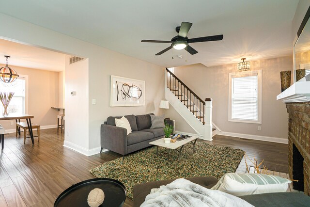 living room with visible vents, baseboards, dark wood-style floors, stairway, and a fireplace