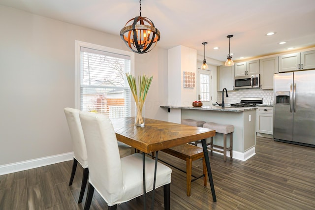 dining room featuring a chandelier, recessed lighting, dark wood finished floors, and baseboards