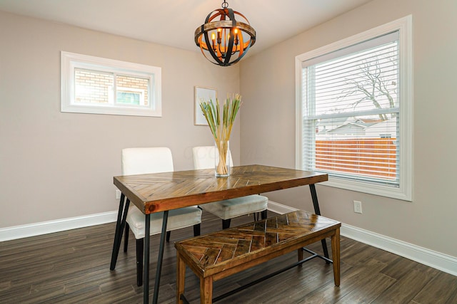 dining area featuring an inviting chandelier, dark wood finished floors, and baseboards