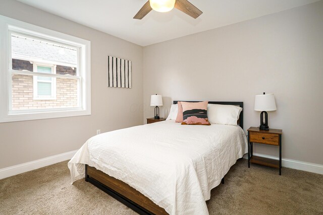 carpeted bedroom with ceiling fan and baseboards