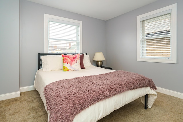 bedroom featuring light carpet and baseboards