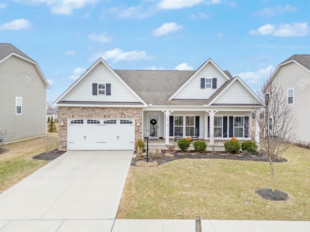 craftsman-style home with a garage, driveway, a porch, and a front lawn