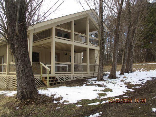 snow covered rear of property featuring board and batten siding