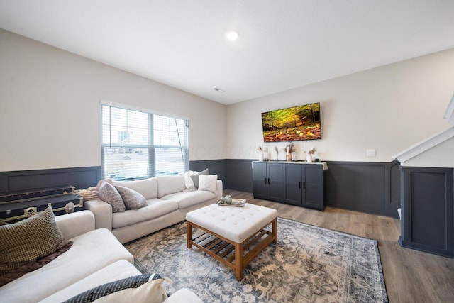 living room with a wainscoted wall and light wood-style floors