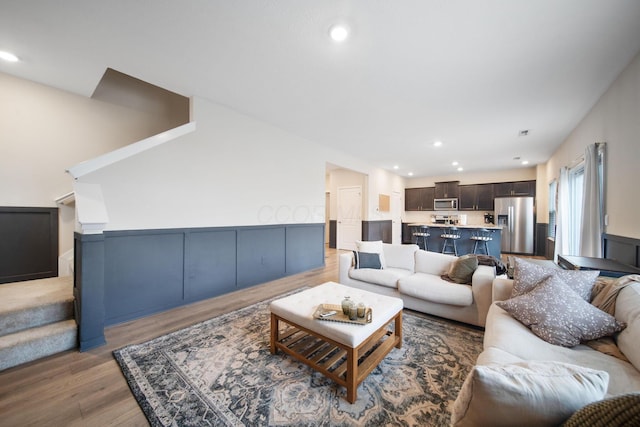 living area with light wood finished floors, stairway, and recessed lighting