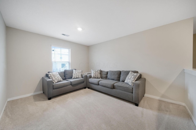 living room with carpet floors, baseboards, and visible vents