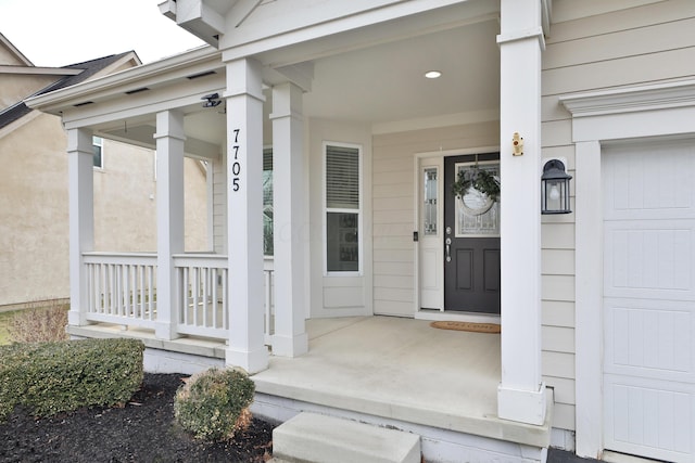 entrance to property featuring a garage and covered porch