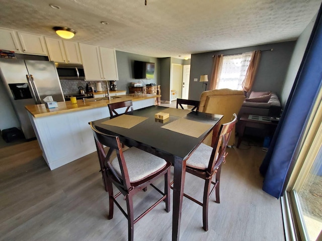 dining area featuring dark wood-style flooring and a textured ceiling