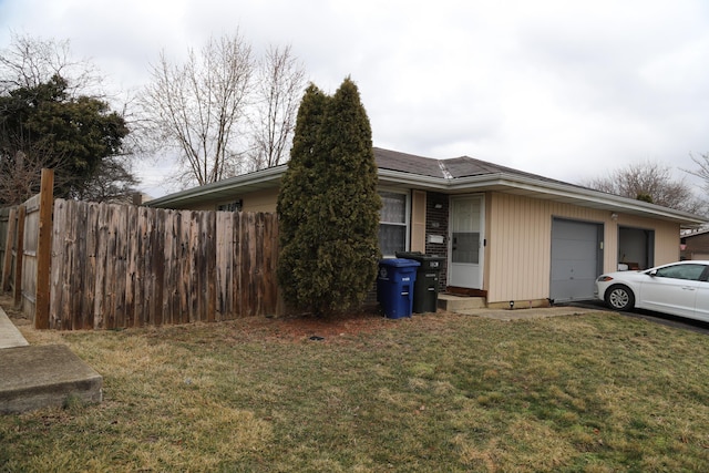 view of front of property with a garage, a front lawn, and fence