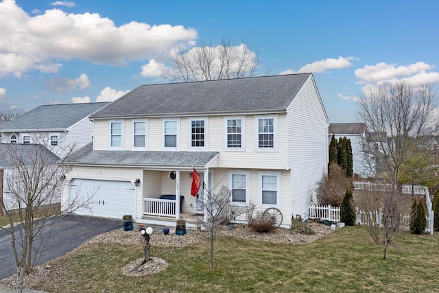 view of front of house featuring driveway, roof with shingles, an attached garage, covered porch, and a front lawn