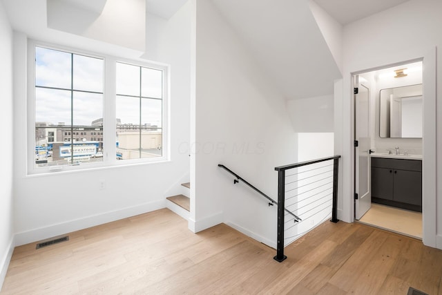 stairs featuring wood finished floors, visible vents, and baseboards