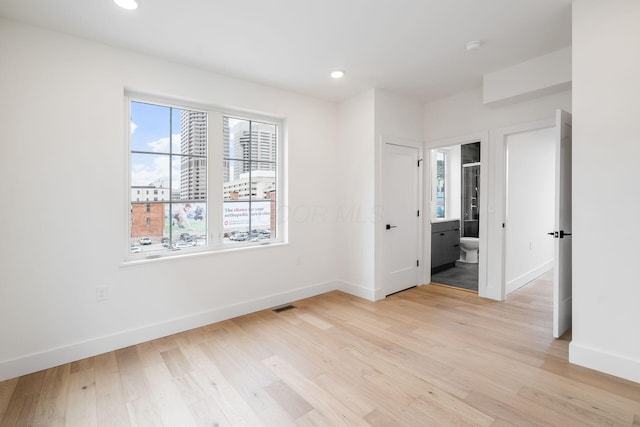 unfurnished room with recessed lighting, baseboards, visible vents, and light wood finished floors